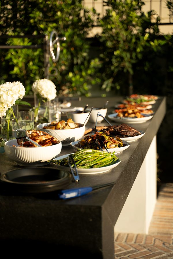Family-style dishes laid out on an outdoor counter